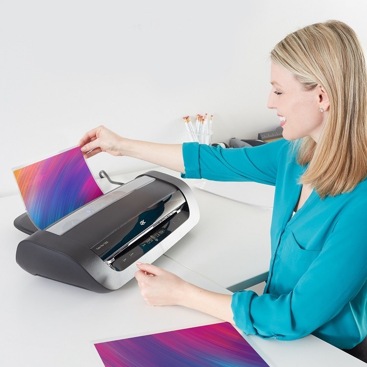 Woman using pouch laminator on a desk