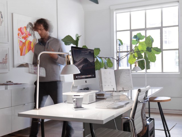 Busy person walking by desk with Kensington ergonomic products implemented