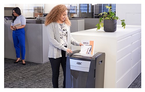 Wide view of woman using GBC shredder